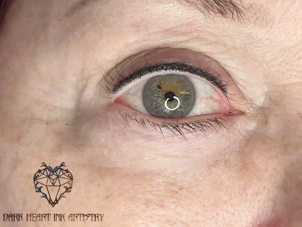 A close up of a woman's eye in a gallery setting.